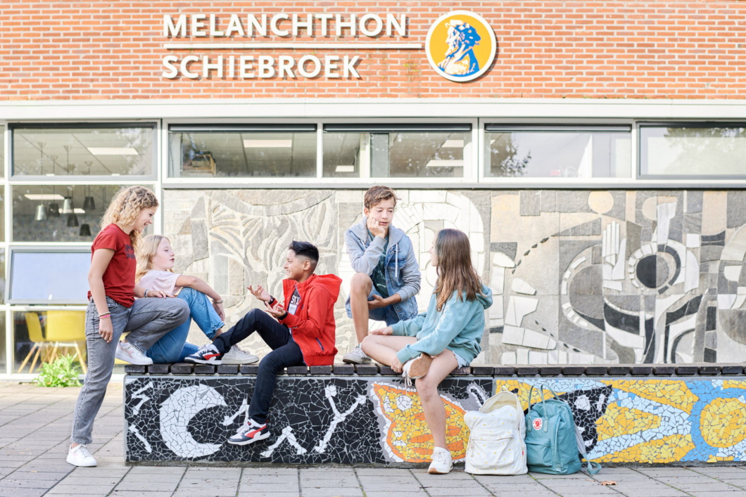 Groepje leerlingen op het plein voor het schoolgebouw van Melanchthon Schiebroek.